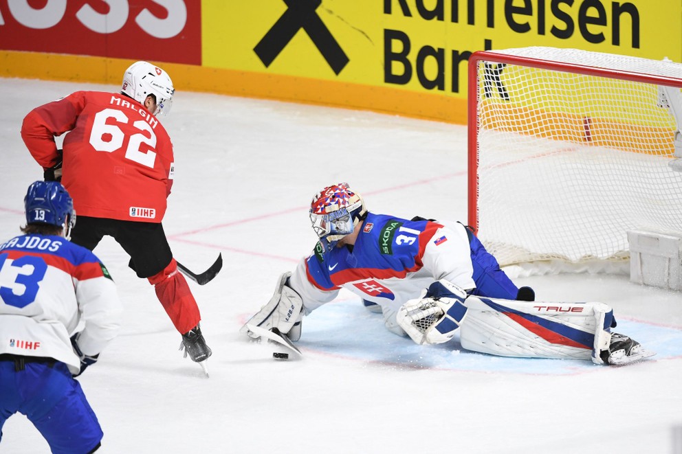 Denis Malgin a brankár Samuel Hlavaj v zápase Slovensko - Švajčiarsko na MS v hokeji 2023.