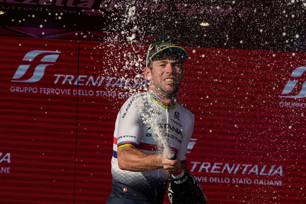 Mark Cavendish oslavuje na pódiu víťazstvo v záverečnej 21. etape Giro d'Italia 2023.