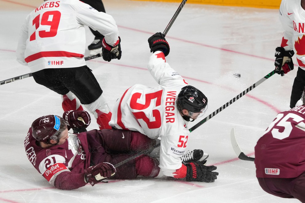 MacKenzie Weegar padá v súboji s Lotyšskom na MS v hokeji 2023.