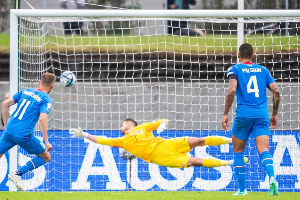 Islanďan Alfred Finnbogasson (vľavo) premieňa penaltu proti Martinovi Dúbravkovi v zápase kvalifikácie na EURO 2024 Island - Slovensko.
