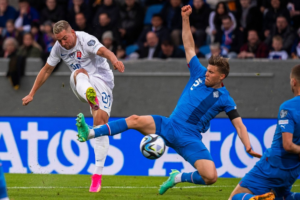 Róbert Mak (vľavo) a Alfonz Sampsted (vpravo) počas zápasu kvalifikácie EURO 2024 J-skupiny Island - Slovensko.