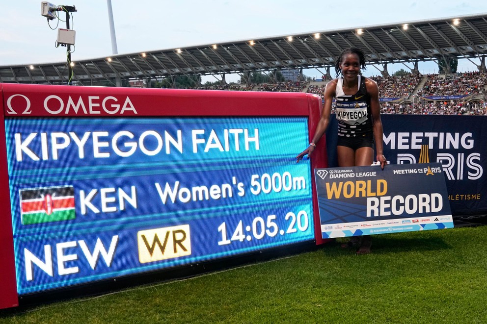 Faith Kipyegonová pózuje pri svetelnej tabuli s novým svetovým rekordom.