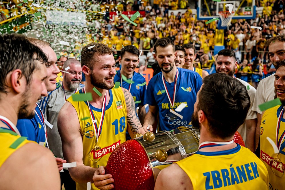 Slovenský basketbalista vo farbách BK Opava Jakub Mokráň drží v rukách trofej pre šampióna českej NBL.