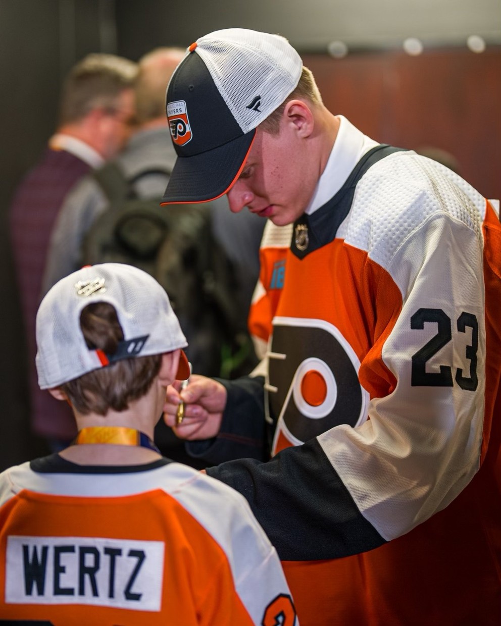 Sedmička draftu NHL 2023 Matvei Mičkov rozdáva autogramy po draftovaní tímom Philadelphia Flyers.