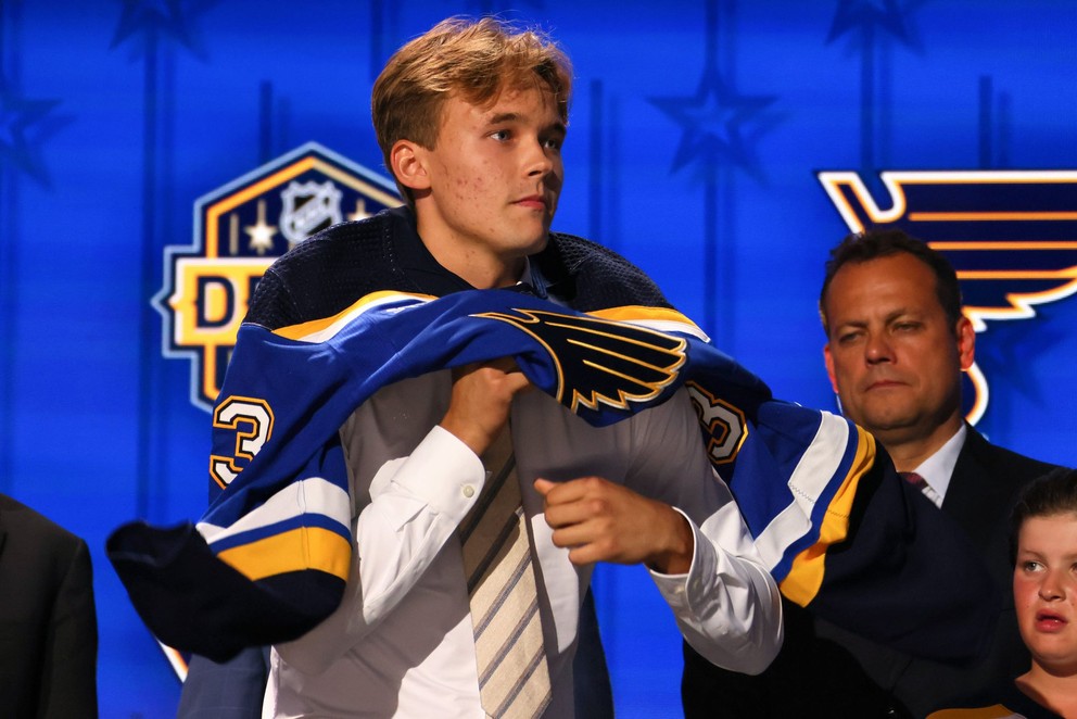 Švéd Theo Lindstein si oblieka dres St. Louis Blues po úspešnom drafte NHL 2023 z 29. pozície.