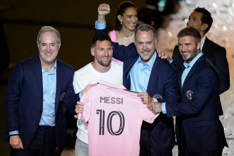 Lionel Messi (uprostred) drží svoj nový dres Interu Miami a pózuje so spolumajiteľmi tímu Jorgem Masom (vľavo), Josém Masom (druhý sprava).