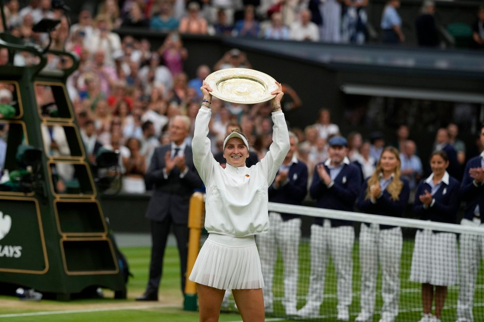 Češka Markéta Vondroušová dvíha nad hlavu trofej pre víťazku Wimbledonu.