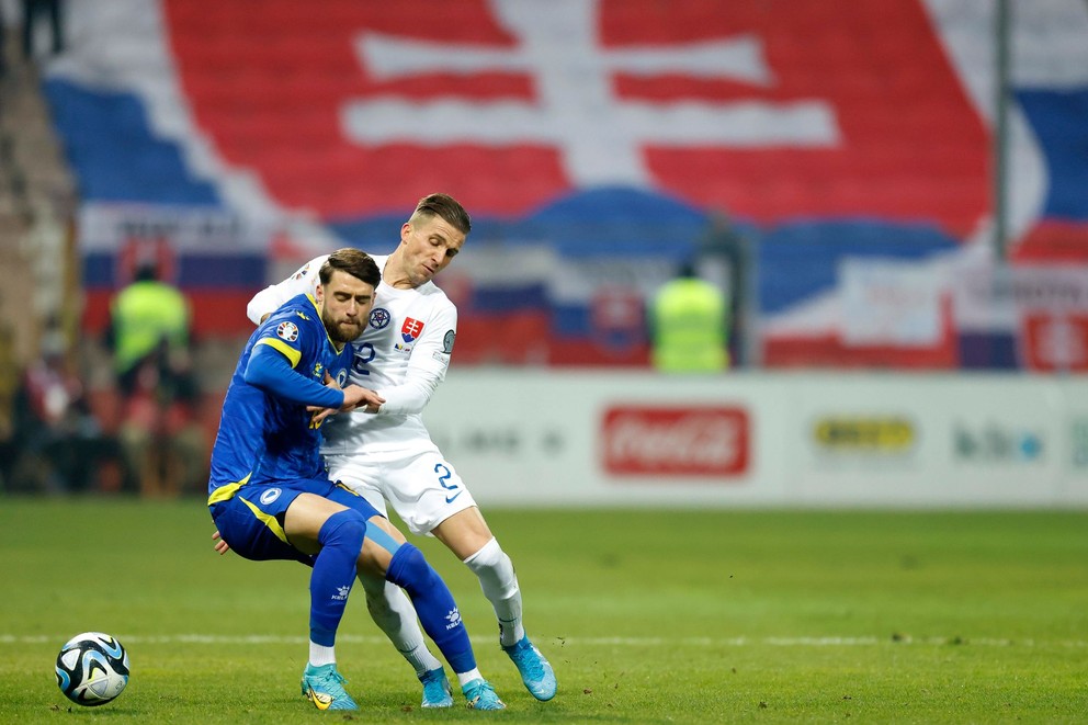 Peter Pekarík Duda v súboji o loptu s Saidom Hamuličom v zápase Bosna a Hercegovina - Slovensko v kvalifikácii na EURO 2024.