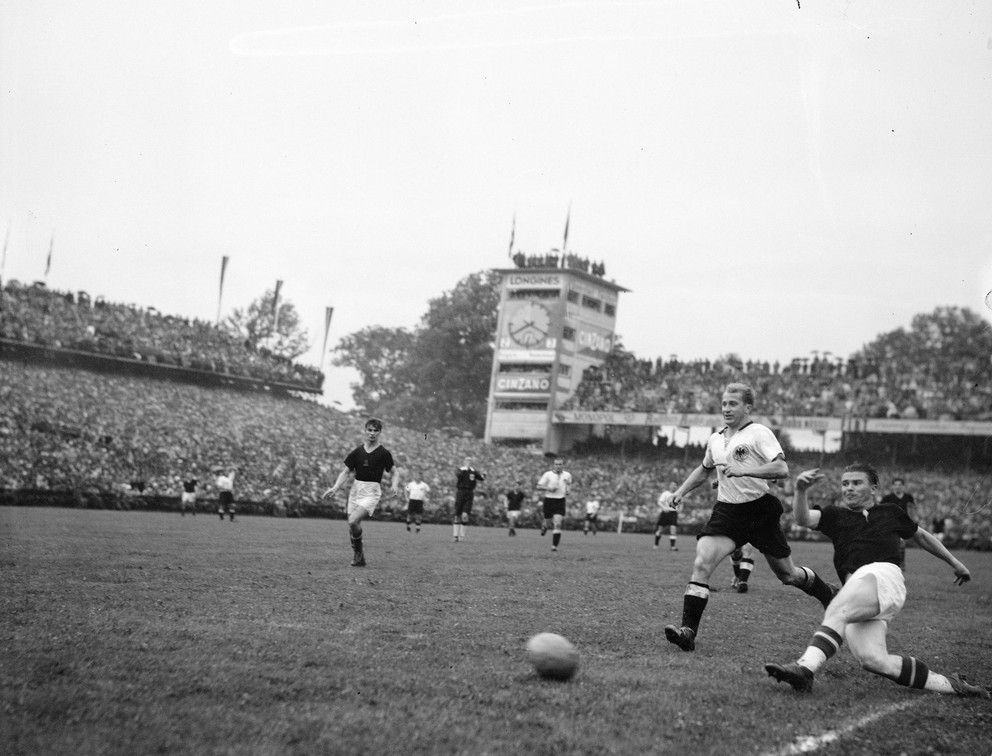 Jimmymu Hoganovi sa pripisuje podiel aj na tom, že krátko po vojne dosiahol maďarský futbal svoj vrchol postupom do finále majstrovstiev sveta v roku 1954 vo švajčiarskom Berne. Na snímke zo zápasu vidno dve najväčšie maďarské hviezdy – v sklze Ferenca Puskása a nabiehajúceho Sándora Kocsisa.