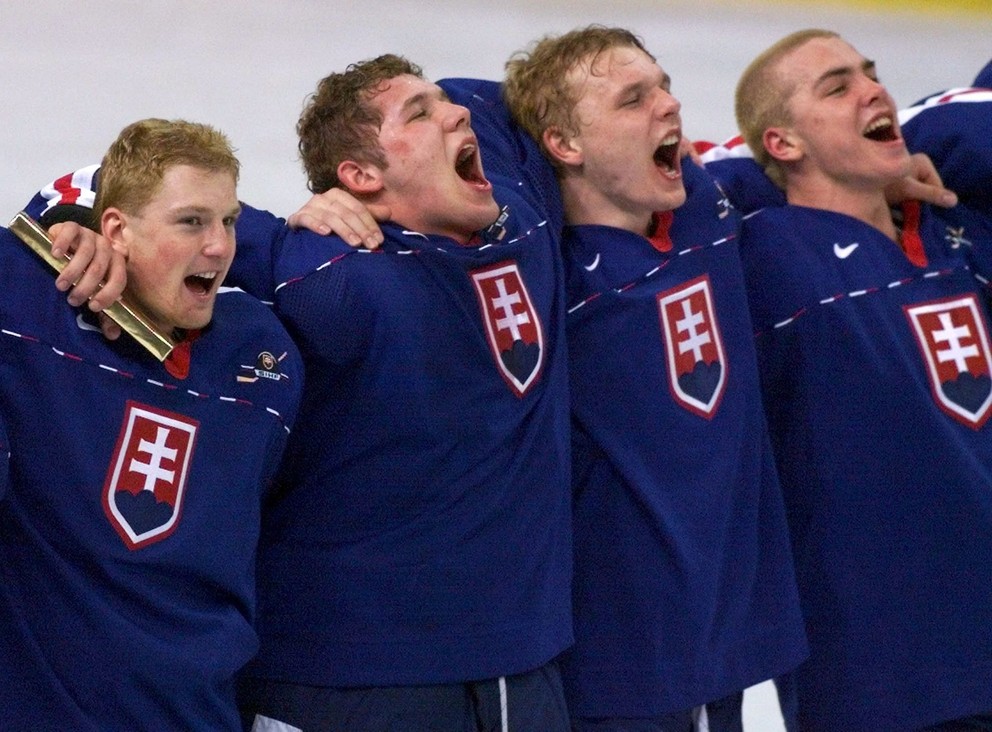 Michal Košík, Ján Lašák, Zoltán Bátovský a Michal Hudec spievajú hymnu po triumfe nad Švédmi v zápase o bronz na MS do 20 rokov vo Winnipegu 1999.
