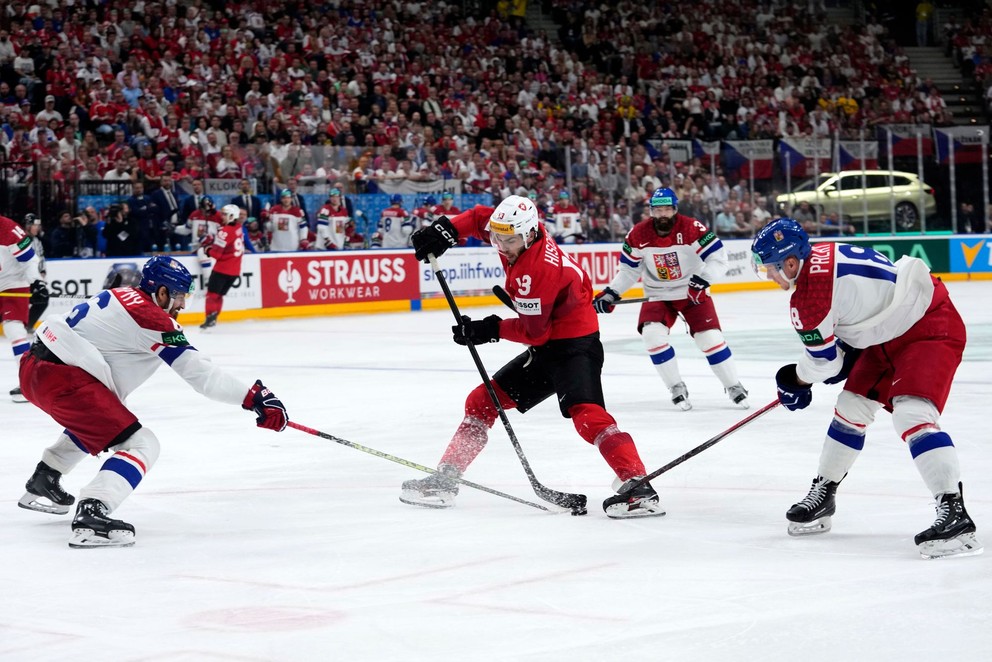 Českí hokejisti Michal Kempný (vľavo) a Ondřej Palát (vpravo) v súboji so Švajčiarom Nicom Hischierom (uprostred) počas MS 2024 v Prahe.