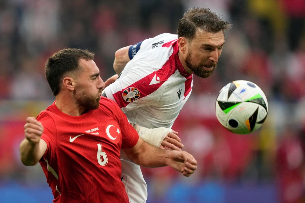 Orkun Kökcü (vľavo) a Guram Kašia v zápase Turecko - Gruzínsko na EURO 2024.