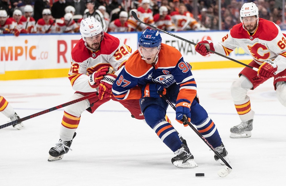 Connor McDavid prenasledovaný MacKenziem Weegarom.