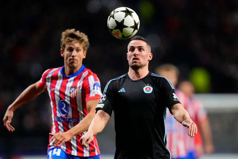 Sprava Róbert Mak (Slovan) a Marcos Llorente (Atlético) v súboji o loptu v zápase 6. kola ligovej fázy Ligy majstrov Atlético Madrid - Slovan Bratislava.