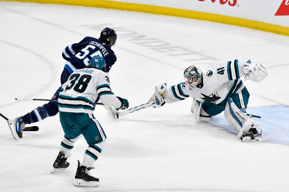 Hokejista Winnipegu Mark Scheifele (vľavo) strieľa víťazný gól na brankára San Jose Sharks Víteka Vaněčeka.