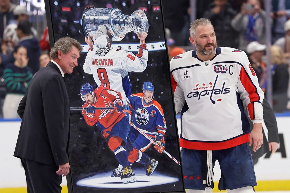 Kapitán Washingtonu Capitals Alex Ovečkin (vpravo), ktorý strelil svoj rekordný 895. gól v kariére, prijíma gratuláciu od legendárneho kanadského útočníka Waynea Gretzkého.
