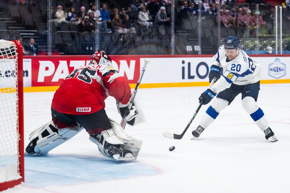 Útočník Eeli Tolvanen (Fínsko) v príležitosti proti svoju bratovi Attemu, ktorý stojí v bránke Rakúska počas MS v hokeji 2025. 