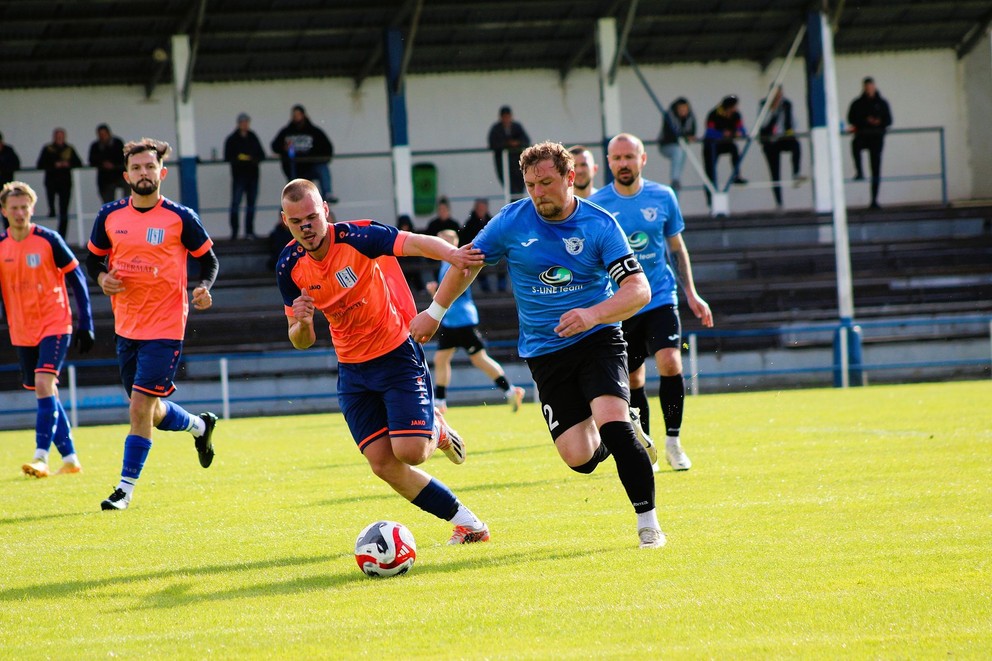 Zo zápasu Nesvady - Iža (2:1), zľava v oranžovom domáci Vladyslav Dubinin, Lukáš Szikora a Daniel Lukacsovics.  