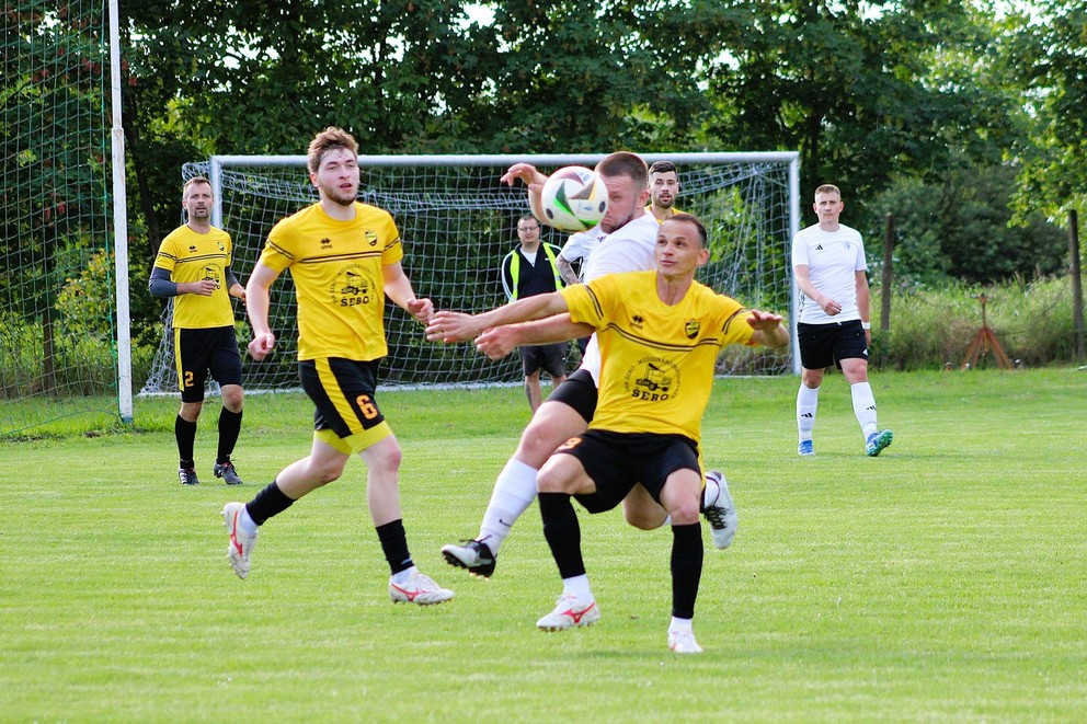 V 27. kole zvíťazil ŠK Podlužany v Iži 4:1. Zľava v žltom Michal Ármai (2), Ivan Drozdov (6) a dvojgólový Andre Da Silva (pri lopte).