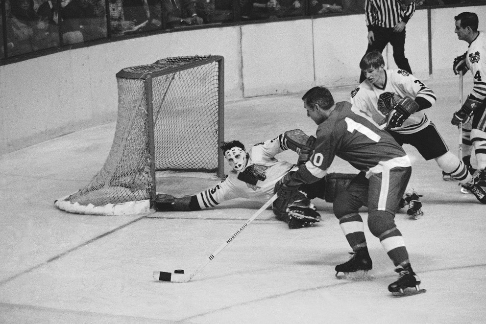 Alex Delvecchio (s pukom na hokejke) bol dlhoročným kapitánom Detroitu Red Wings.