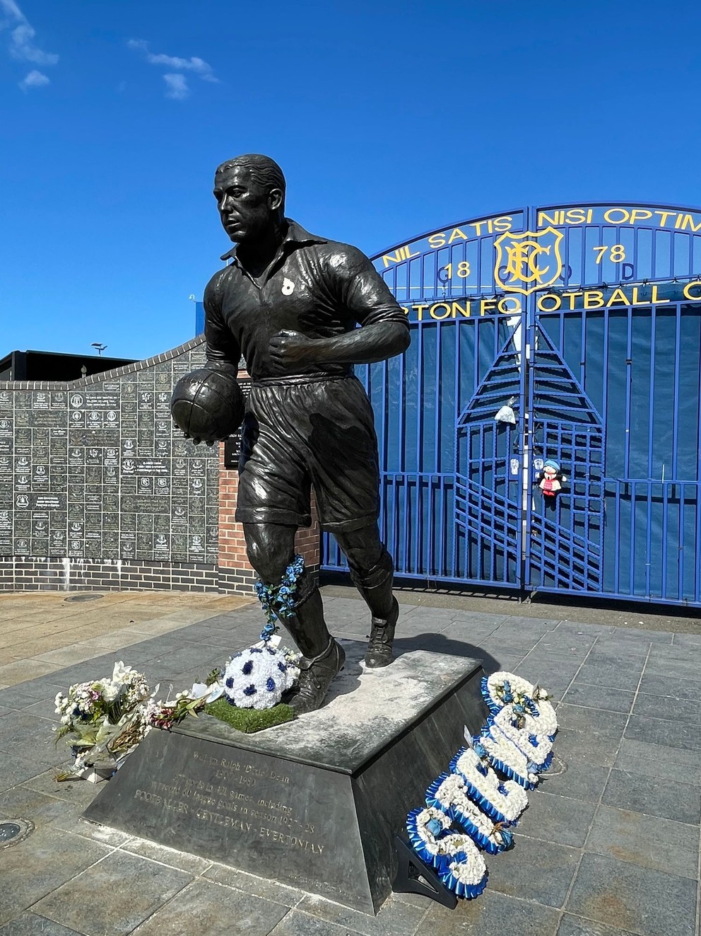 Socha Williama Ralpha „Dixieho“ Deana, slávneho útočníka, ktorý dodnes drží rekord v počte gólov v jednej sezóne v najvyššej anglickej futbalovej súťaži. V sezóne 1927/28 strelil 60 gólov (zo 102 svojho tímu) a výrazne prispel k zisku titulu Evertonu.