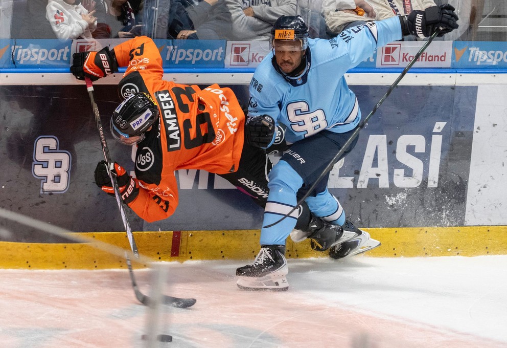 Sena Acolatse (Slovan) a Patrik Lamper (Košice) bojujú pri mantineli v zápase 1. kola hokejovej Tipsport ligy HC Slovan Bratislava - HC Košice.