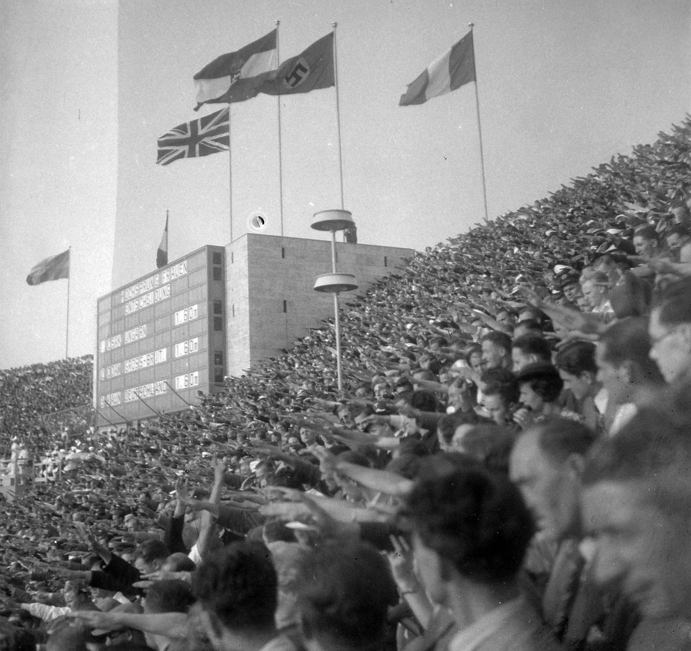 Diváci so vztýčenou pravicou, čo bol nacistický pozdrav, na Olympijskom štadióne v Berlíne počas OH 1936.
