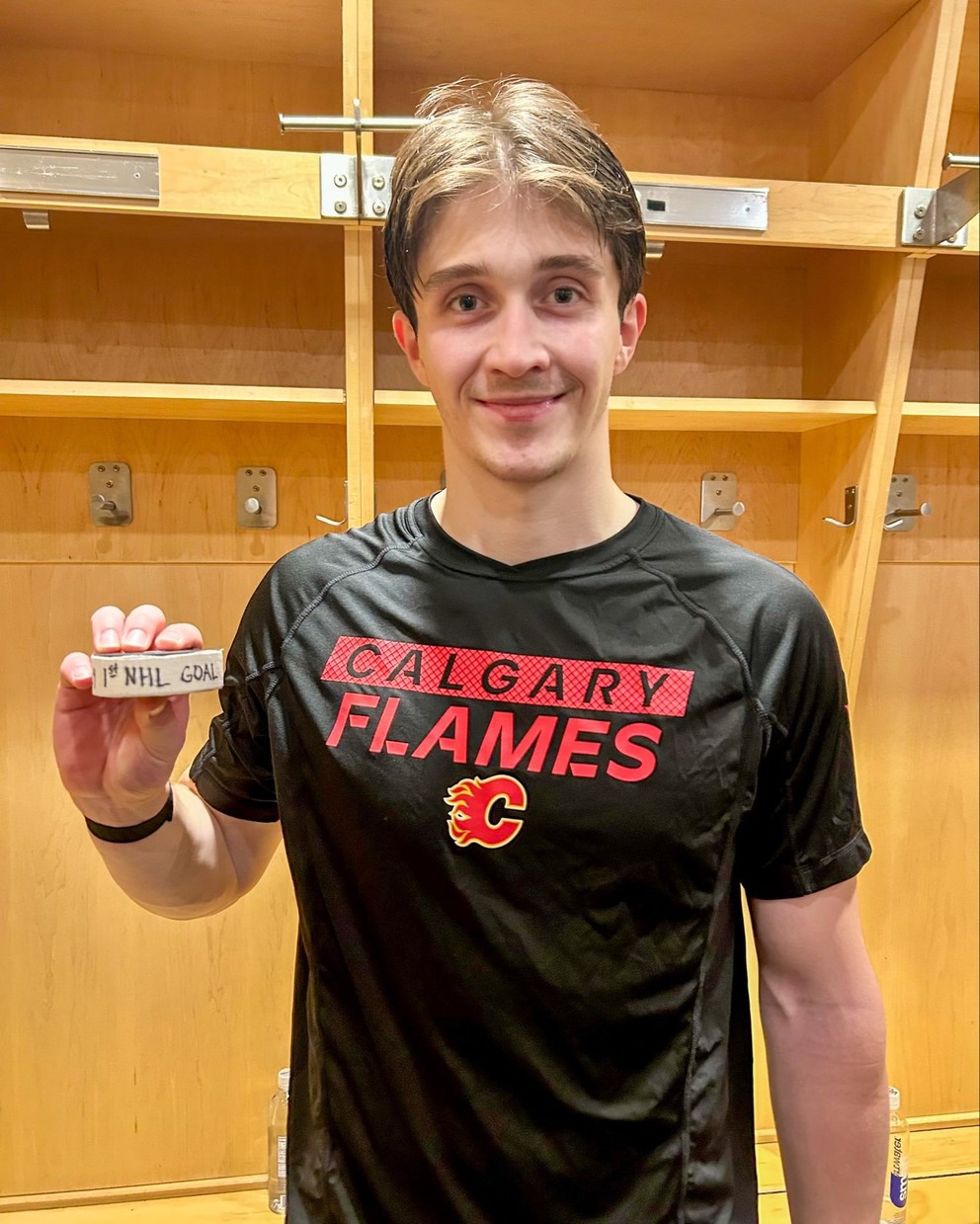 Samuel Honzek pózuje s pukom po premiérovom góle v NHL