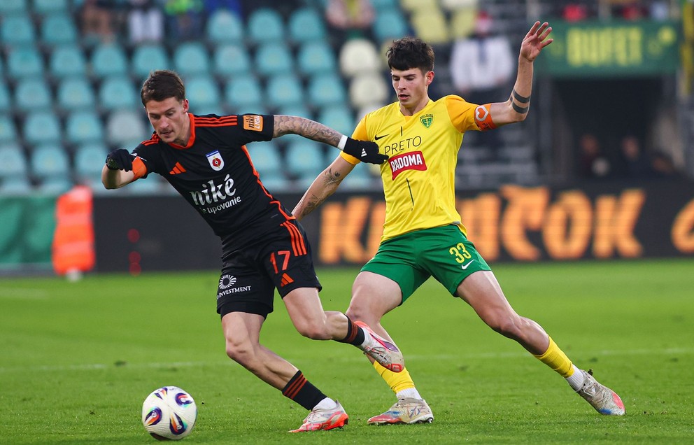Na snímke sprava Tobiáš Pališčák (Žilina) a Adam Tučný (Ružomberok) bojujú o loptu v zápase 17. kola futbalovej Niké ligy.