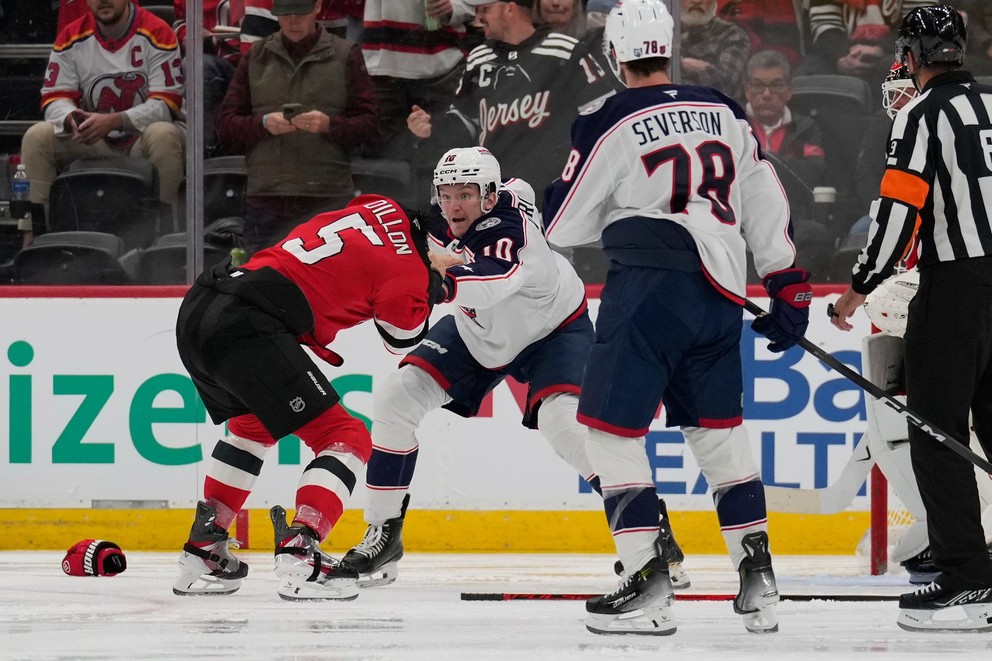 Hráč New Jersey Devils Brenden Dillon (vľavo) sa bije s hráčom Columbus Blue Jackets Dmitrijom Voronkovom (druhý zľava) počas zápasu NHL.