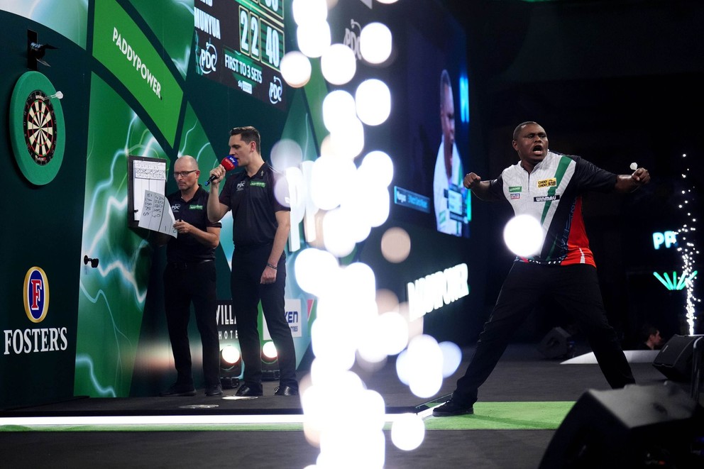 David Munyua sa teší po víťazstve nad Mikeom De Deckerom na MS v šípkach 2026.