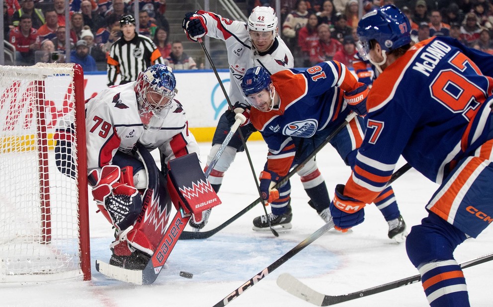 Slovenský hokejista v drese Washingtonu Martin Fehérváry (42), brankár Washingtonu Charlie Lindgren (79) a kapitán Edmontonu Connor McDavid (97) počas zápasu.