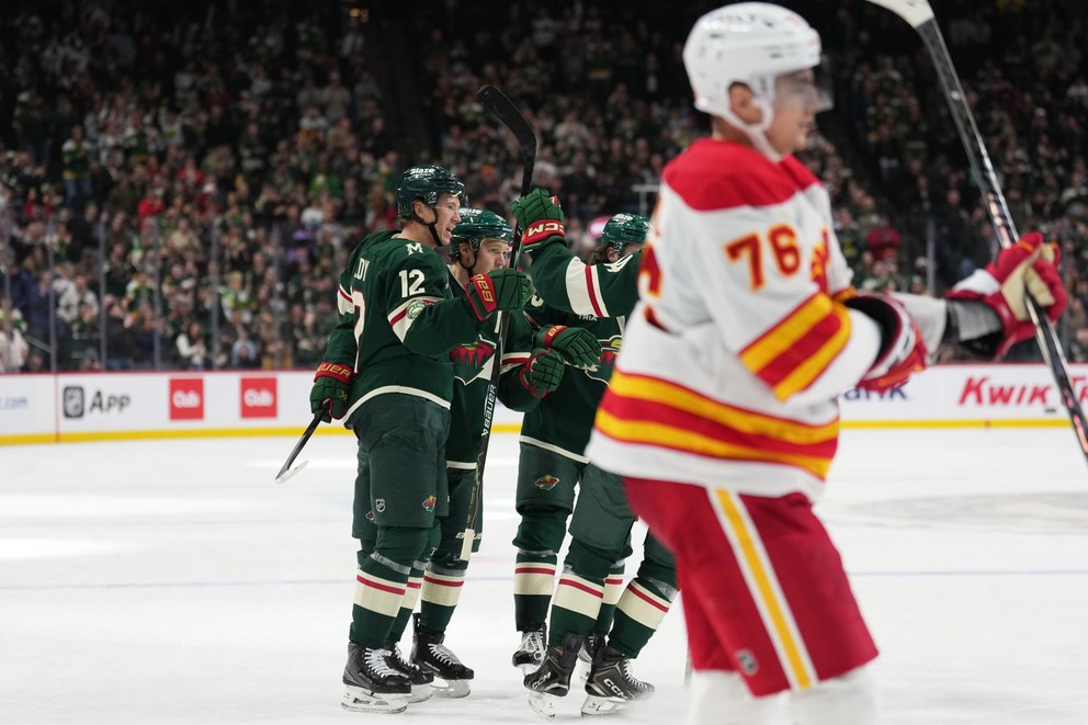 Na snímke hráč Minnesoty Matt Boldy (vľavo v pozadí) sa raduje so spoluhráčmi po strelení gólu v zápase zámorskej NHL Minnesota - Calgary. V popredí slovenský hráč Calgary Martin Pospíšil (76).