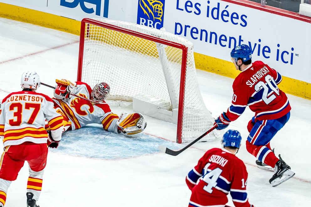 Juraj Slafkovský v šanci pred brankárom Calgary Dustinom Wolfom.