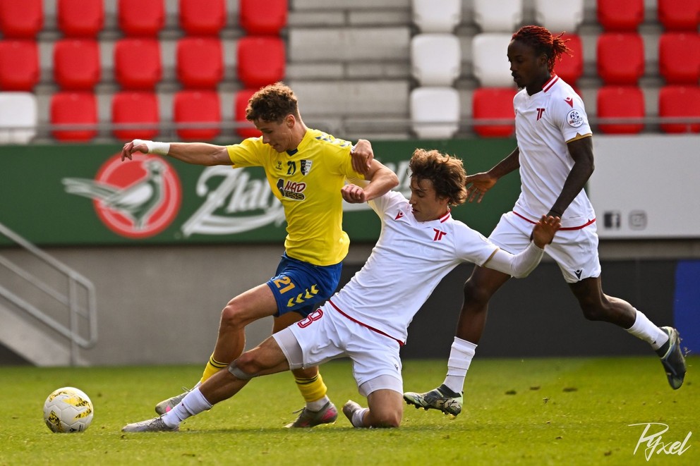 Zo zápasu Trenčín B – Myjava v súboji o loptu v bielom Trenčan Bednár.