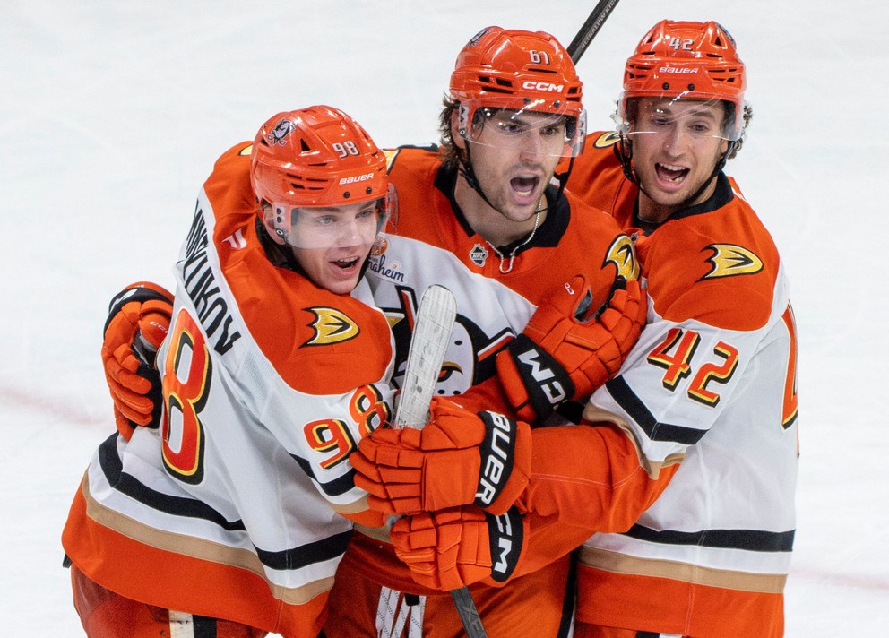 Hráči Anaheim Ducks Pavel Minťukov, Cutter Gauthier a Tim Washe oslavujú gól.