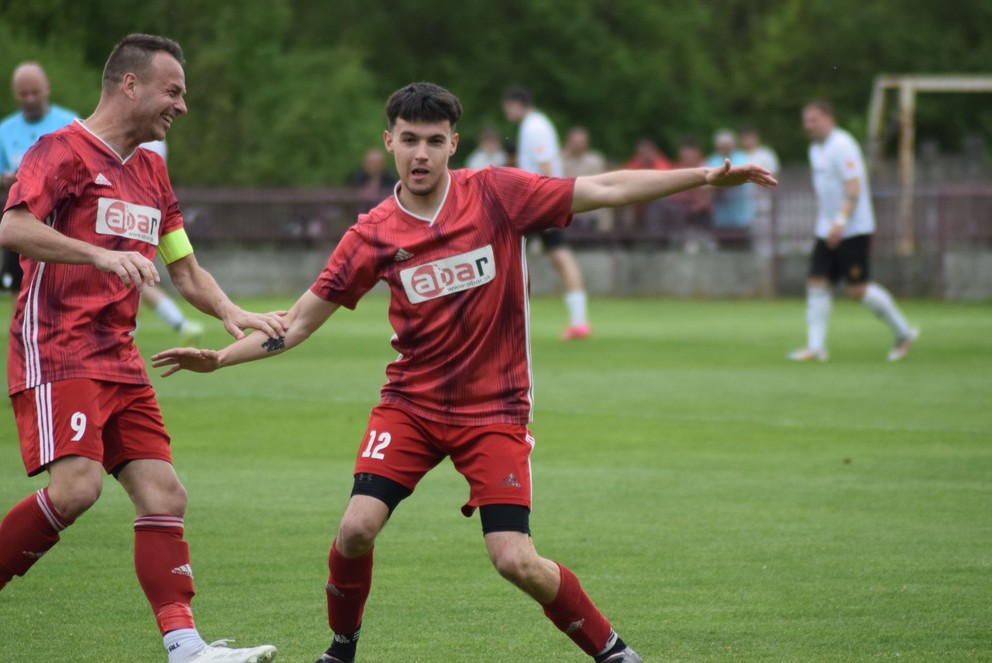 Strelcovi nedeľňajšieho gólu proti Komoči Lukášovi Petrášovi (12) gratuluje hrajúci prezident FC Komjatice Martin Marenčák.