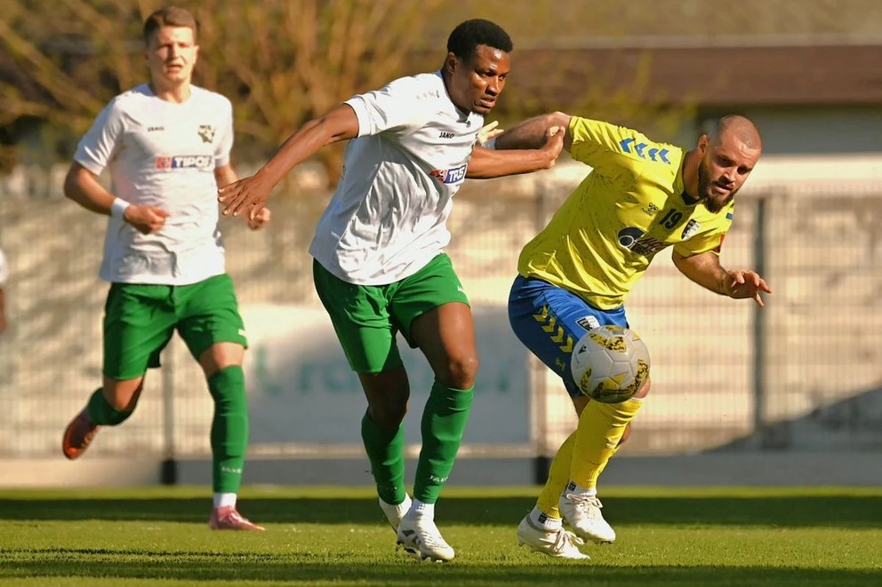 V súboji o loptu Dominik Martišiak (v žltom) a Novozámčan Bankole, ktorý predtým na bránkovej čiare zabránil Myjavčanovi skórovať.