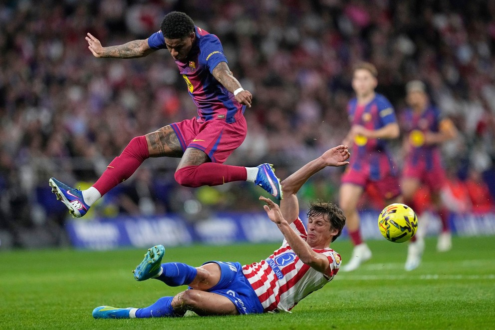 Futbalista Barcelony Marcus Rashford (hore) a hráč Atletica Madrid Robin Le Normand bojujú o loptu