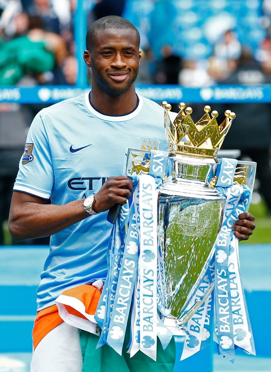 Yaya Touré v drese Manchestru City s trofejou.