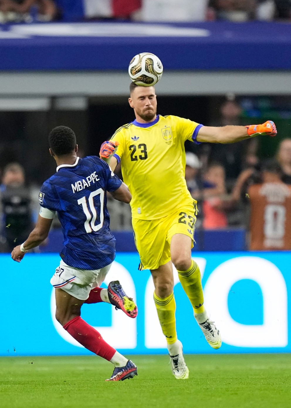 Brankár Španielska Unai Simón odhlavičkuje loptu pred útočníkom Francúzska Kylianom Mbappém počas semifinálového zápasu majstrovstiev sveta medzi Francúzskom a Španielskom v Arlingtone v Texase neďaleko Dallasu,