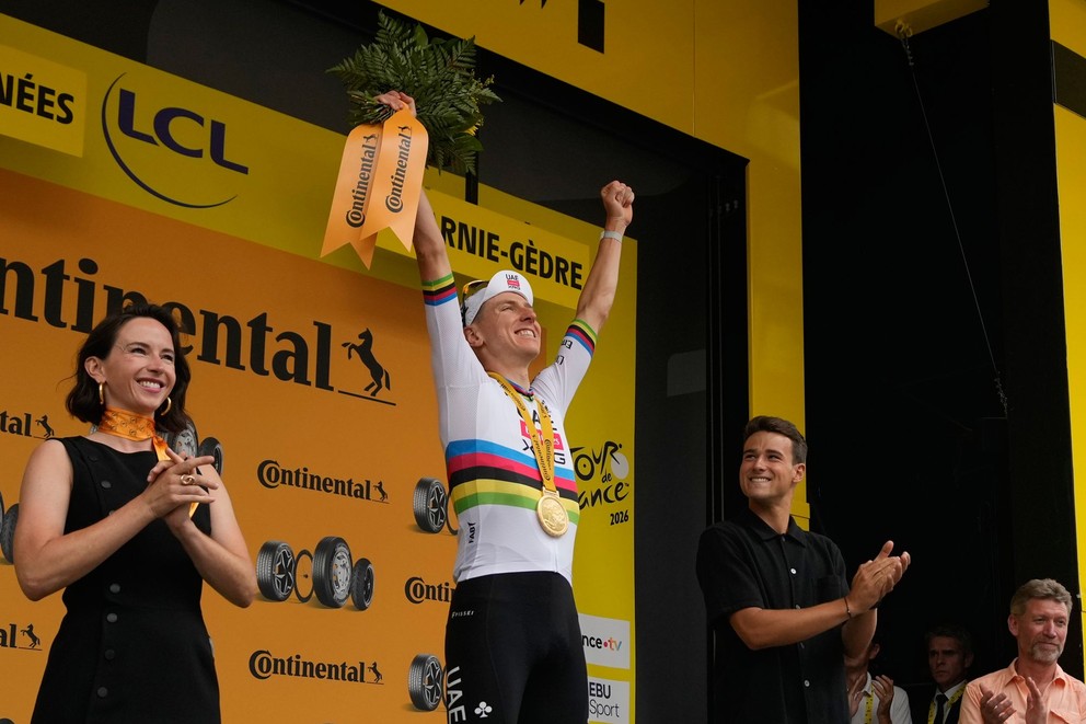 Slovinský cyklista Tadej Pogačar sa na pódiu raduje po výhre v 6. etape Tour de France 2026.