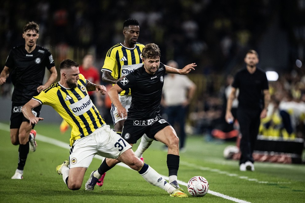 Slovenský futbalista v drese Fenerbahce Istanbul Milan Škriniar (druhý zľava) a hráč SK Sturm Graz Simon Seidl počas prvého zápasu 3. predkola Ligy majstrov.