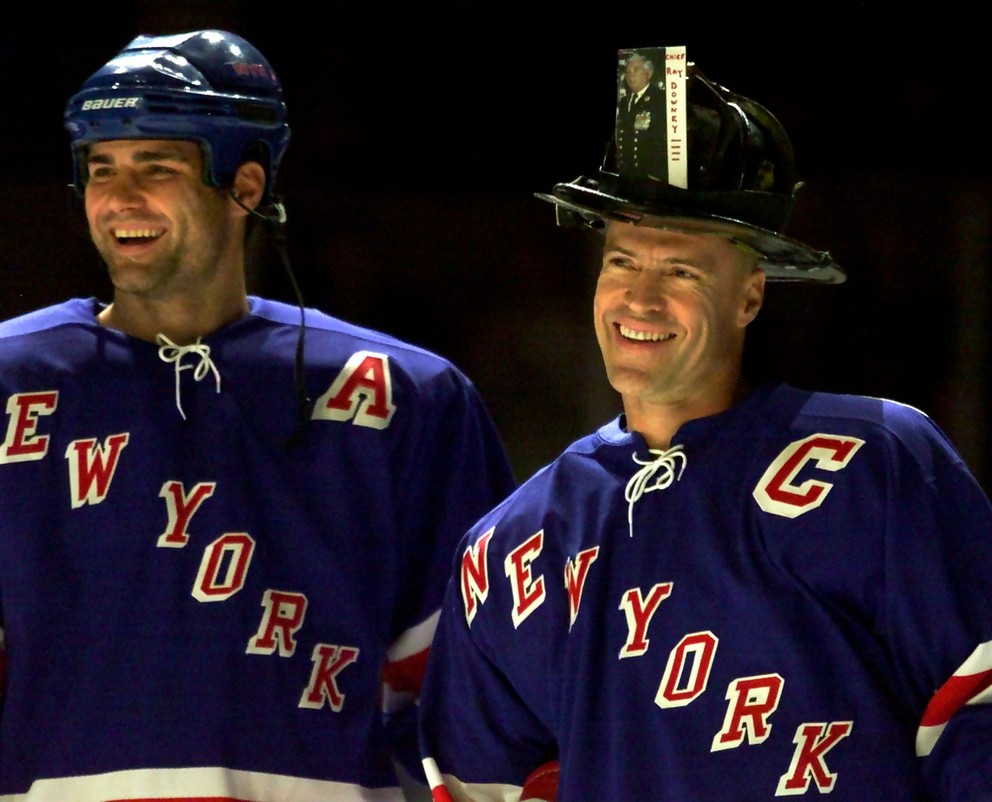 Mark Messier (vpravo) s prilbou na hlave ako pocta hasičom a jeho spoluhráč Eric Lindros. 
