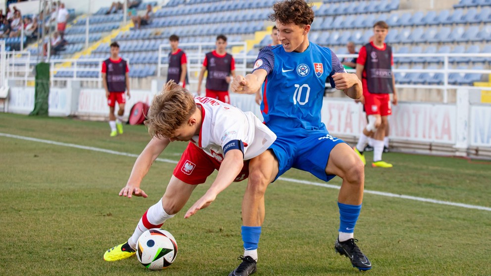 V nominácii slovenskej osemnástky nechýba Šimon Vlna (na ilustračnej snímke v modrom v súboji s Mateuszom Dziweiatowskim v zápase Poľsko – Slovensko na UEFA Majstrovstvách Európy hráčov do 17 rokov 2024 na Cypre – Achna, 27.5.2024)