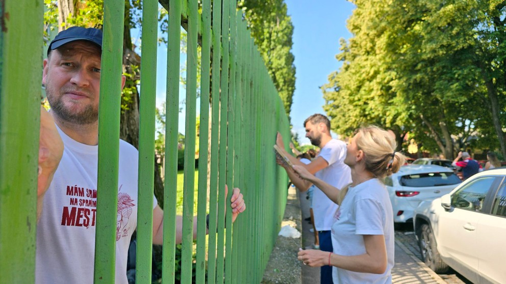 Zamestnanci SFZ natierajú plot na ZŠ Vrútocká v Bratislave