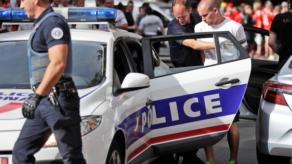 Policajt vedie zatknutého ruského fanúšika pred zápasom na Euro 2016 - archívna fotografia.