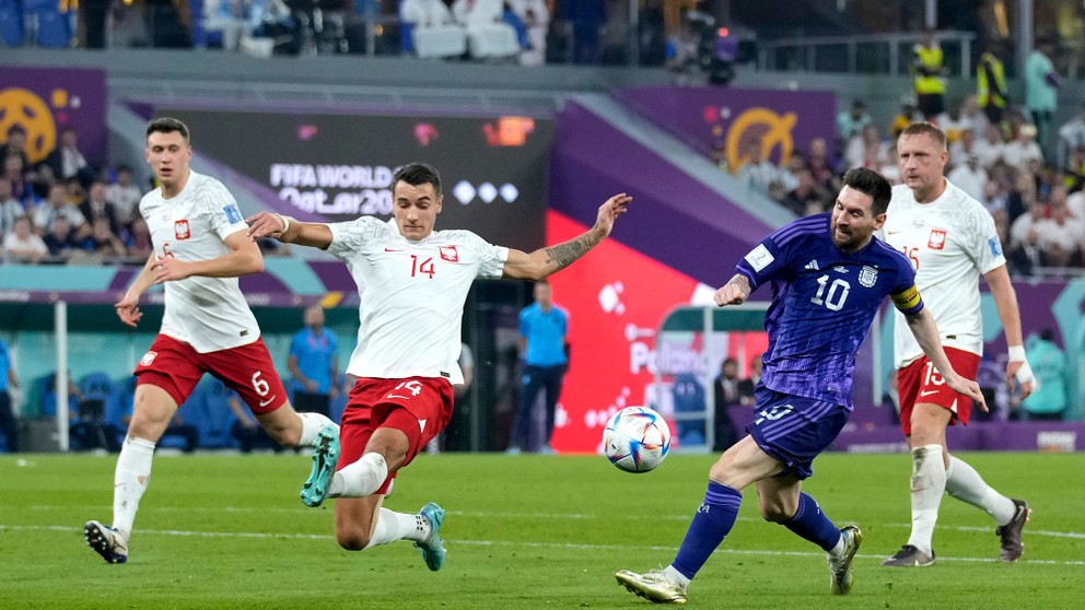 Poľský futbalista Jakub Kiwior sa na MS 2022 snaží zabrániť vystreliť Lionelovi Messimu.